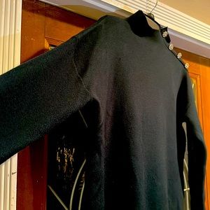 Green sweater with diamond buttons on left shoulder